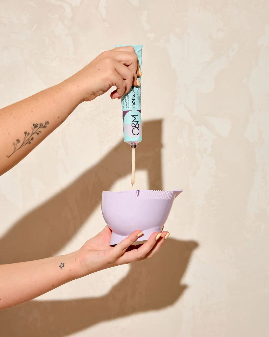 Stylist dispensing O&M CØR. colour hair dye into a Foxy Blondes light lilac professional mixing bowl