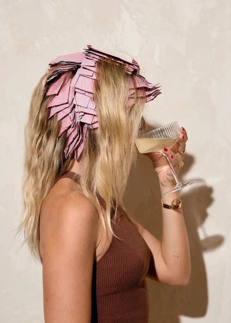 Blonde woman relaxing and sipping champagne while Foxy Blondes 'Tickle Me Pink' hair foils are applied for a highlighting treatment.